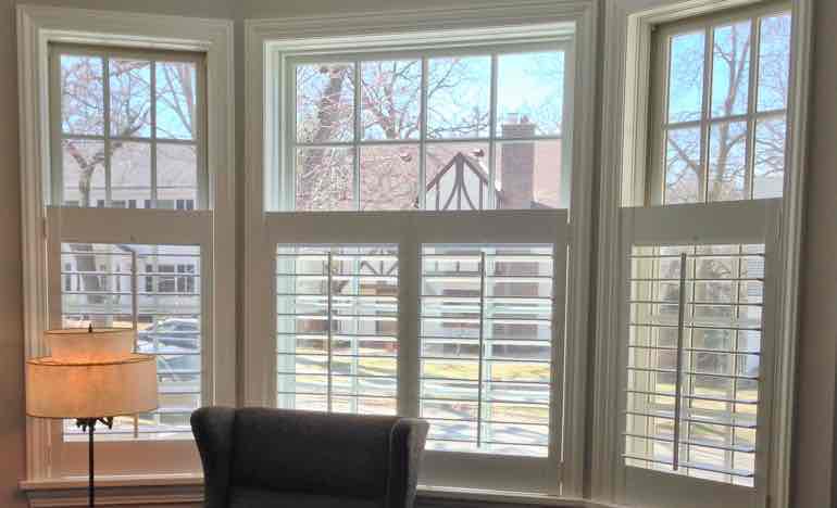 Half-length insulating shutters in family room bay window.